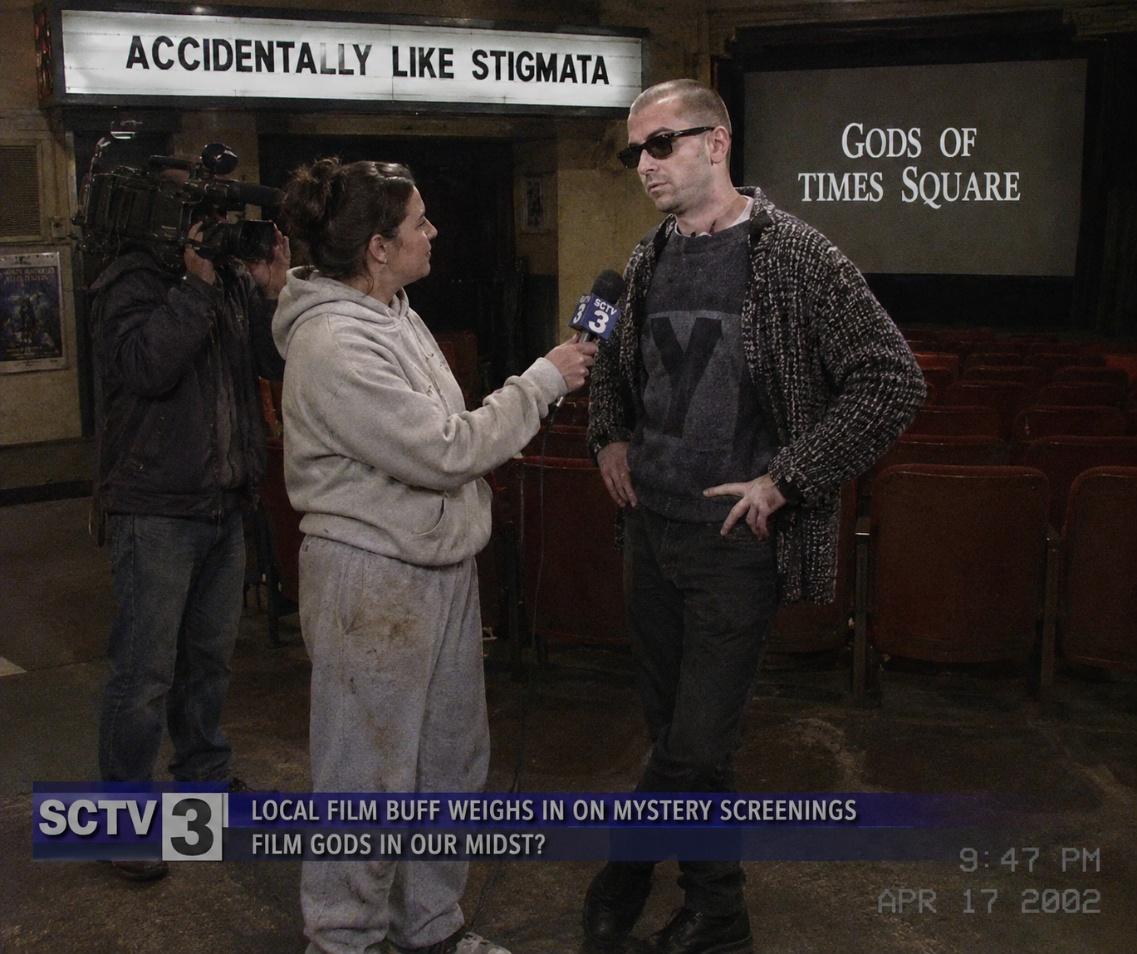 Local SCTV 3 reporter interviewing MacLeod in a theatre beneath the marquee Accidentally Like Stigmata, dated April 17 2002