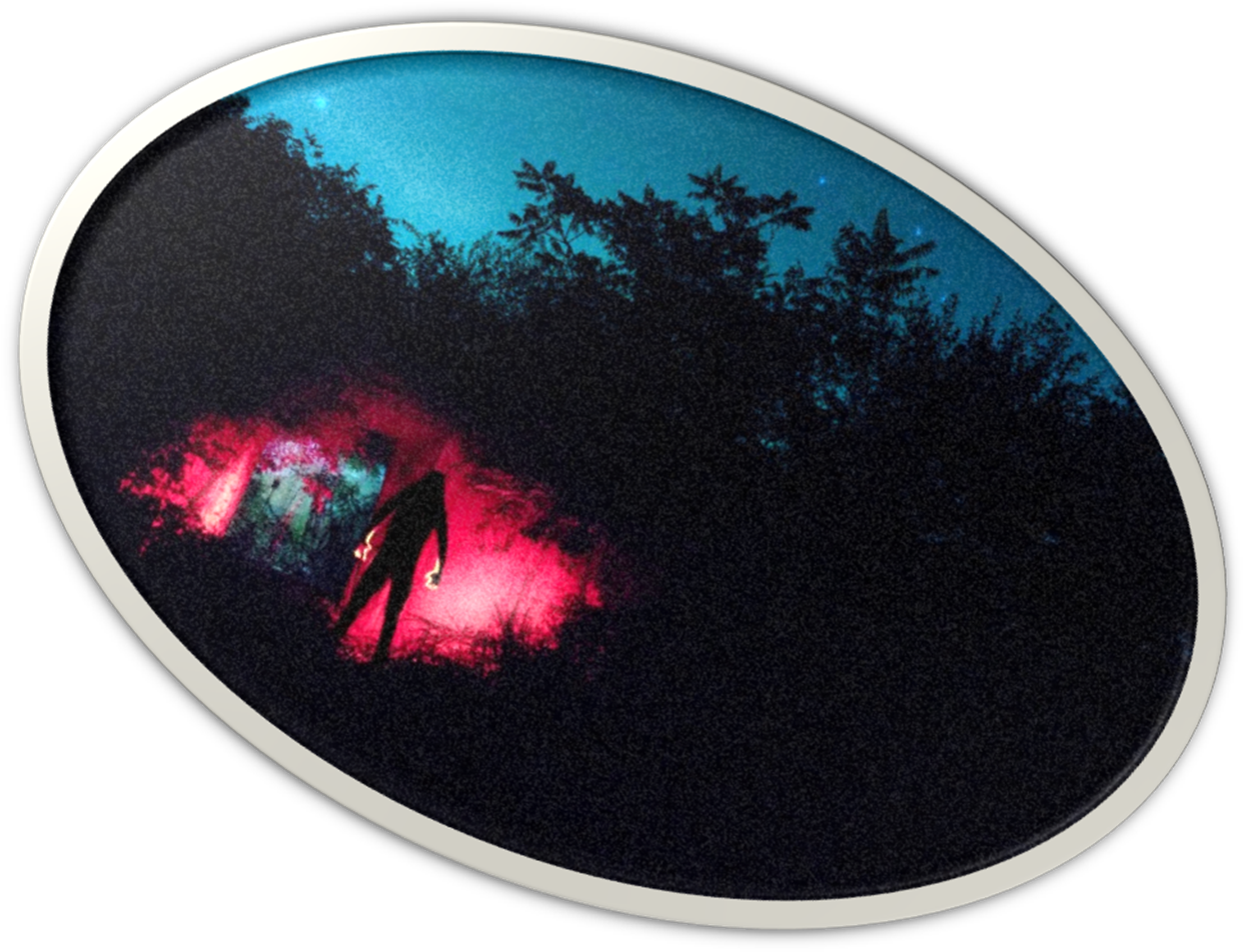 Dark figure approaching a red-lit doorway in a wooded place